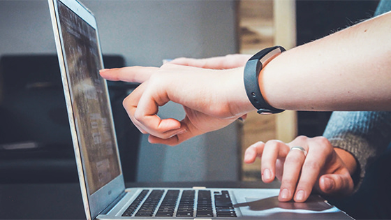 person pointing at a laptop screen with another person; image used for blog post about not-for-profit