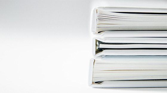 a stack of white binders filled with paper; image used for blog post about not-for-profits having a code of ethical conduct
