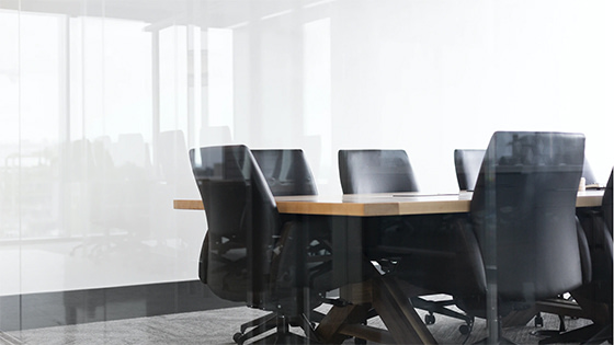 six black leather chairs sit around a wooden table in a conference room; image used for blog post about a not-for-profit advisory board