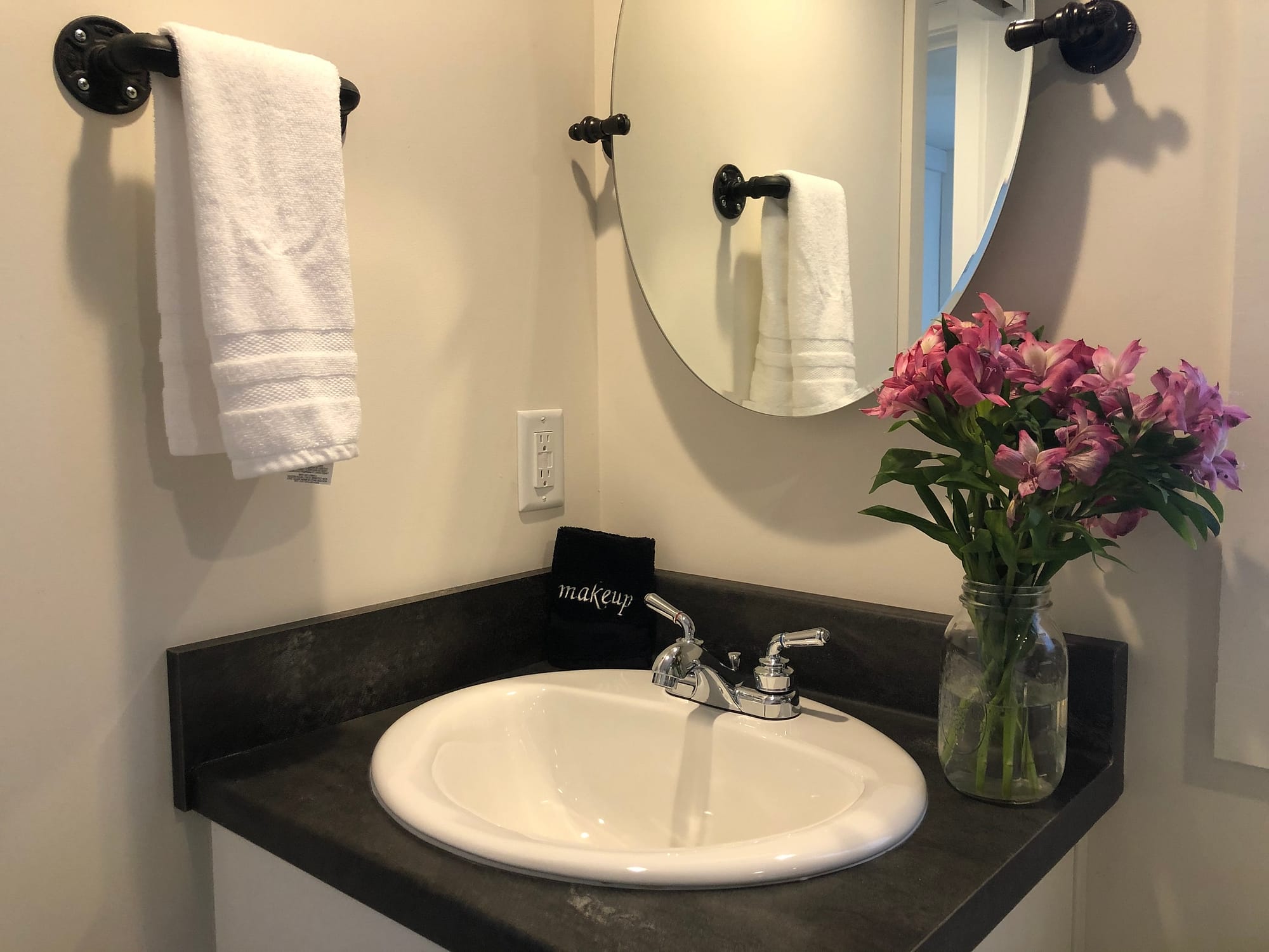 bathroom sink with towel and flower vase