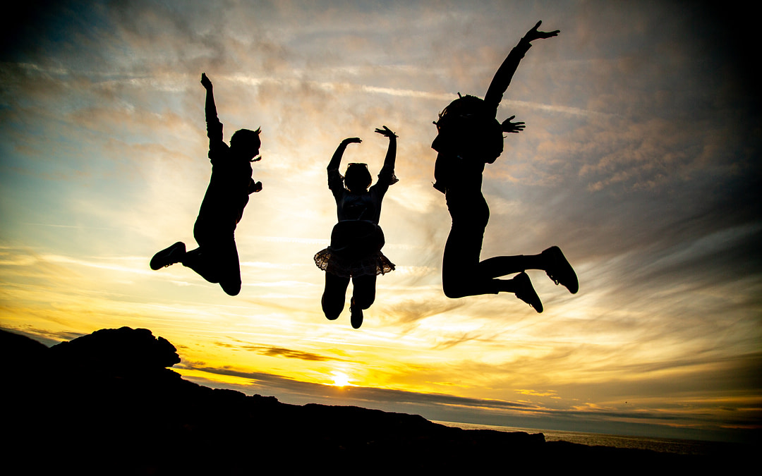 Teens jumping in front of sunset
