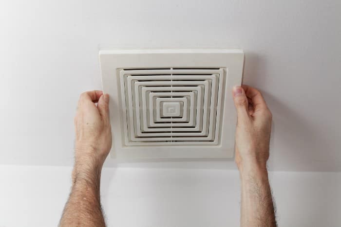 air duct cover Hands removing or installing an air duct cover from a ceiling vent for maintenance or cleaning