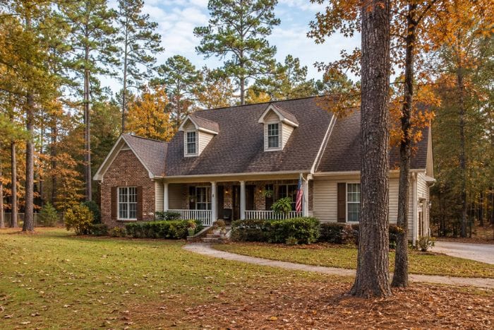East Texas home with heavy pine and oak tree coverage around the roofline