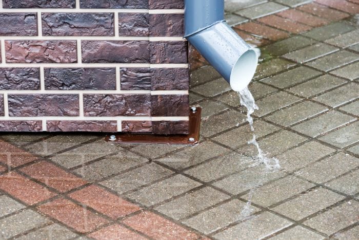 Downspout draining rainwater away from the side of an East Texas home