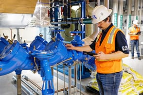 EAB Cx engineer inspecting a backflow preventer in a commercial plumbing system