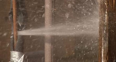 water gushing out of broken pipe