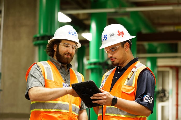 two building commissioning engineers looking at a digital tablet