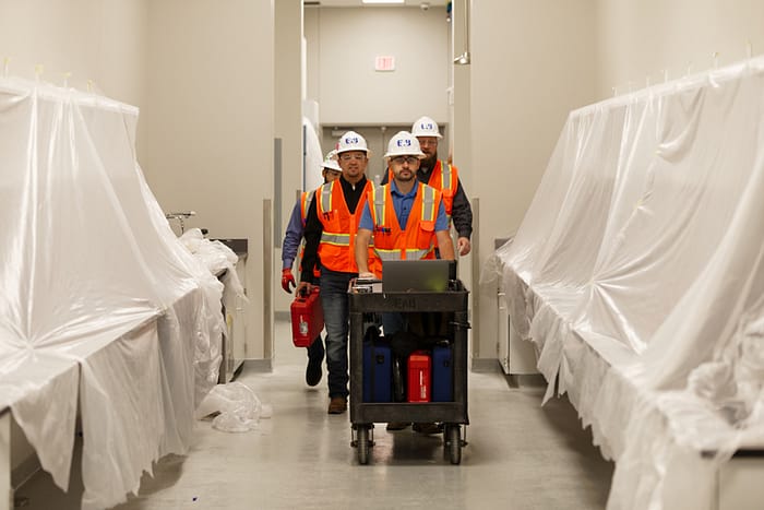 EAB engineers transporting equipment through a hallway.