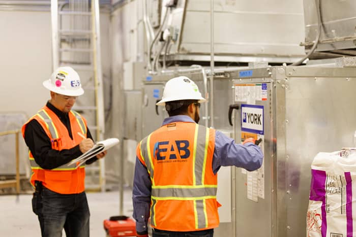 HVAC professionals from EAB documenting system performance during testing and balancing procedures