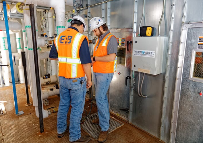 Commissioning technicians performing BAS integration testing on HVAC equipment