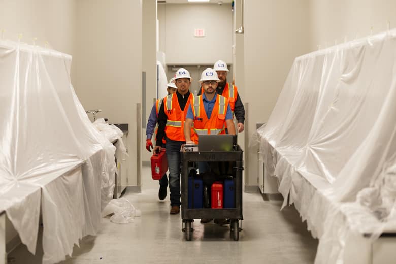 EAB engineers transporting equipment through a hallway.