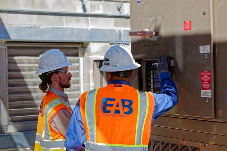 EAB engineers inspecting an outdoor HVAC unit