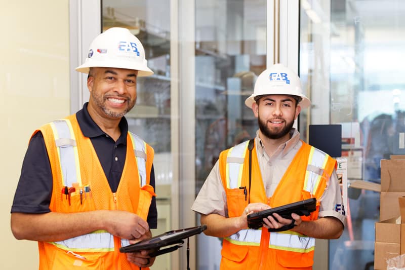 Two smiling tab professionals from EAB