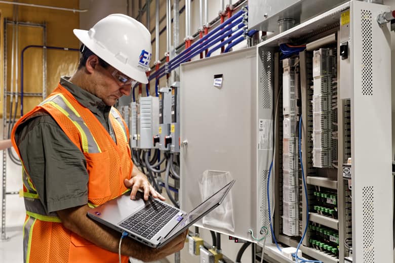 An EAB engineer testing equipment using a laptop on-site