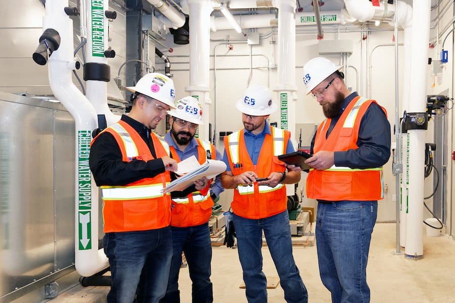 EAB commissioning engineers reviewing a commissioning plan on-site in a mechanical room