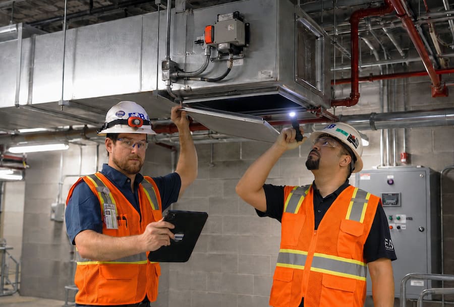 EAB technicians inspecting ductwork before smoke control testing