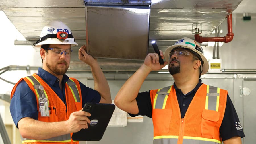 Cx engineers conducting HVAC system inspection as part of the commissioning process