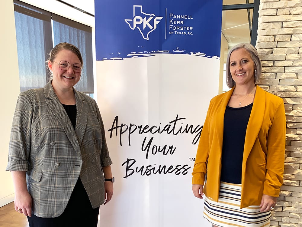 A photo of two people standing with a poster that says "Appreciating Your Business™" for the PKF Texas seminar, "2022 Accounting and Tax Updates and Changes for Not-for-Profits"