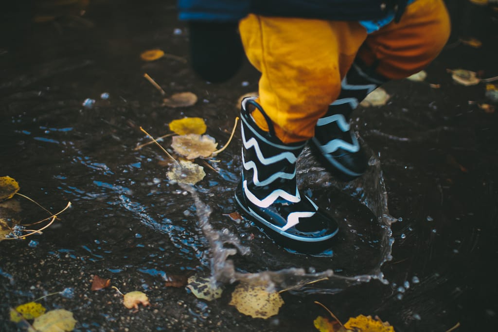 Kids playing in the rain in boots