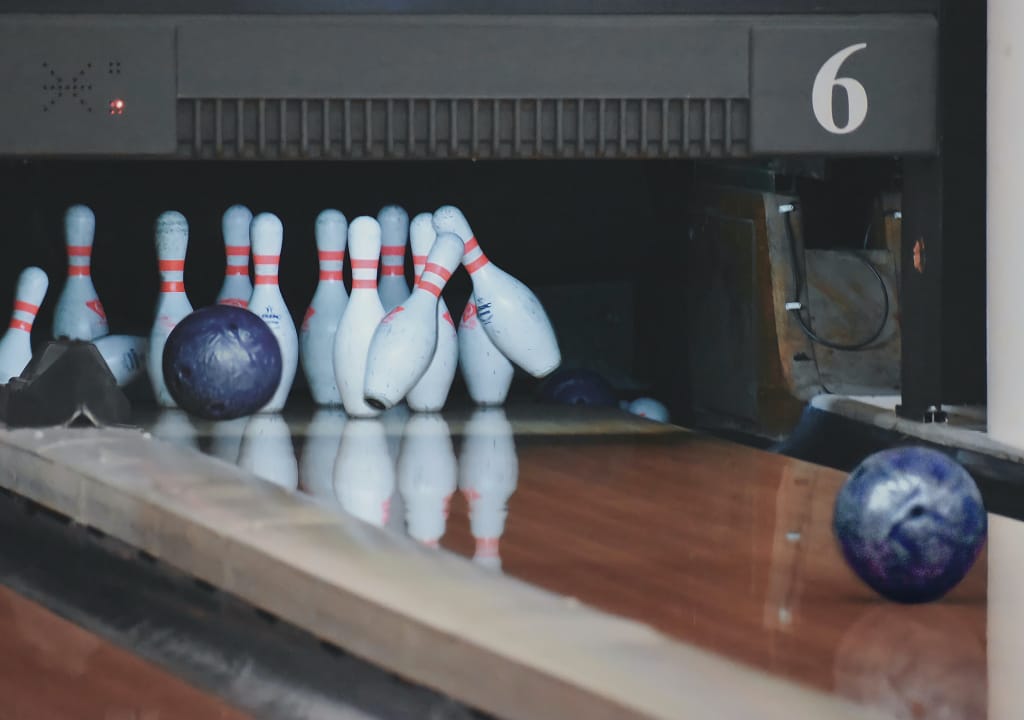 Bowling lane with ball knocking pins over