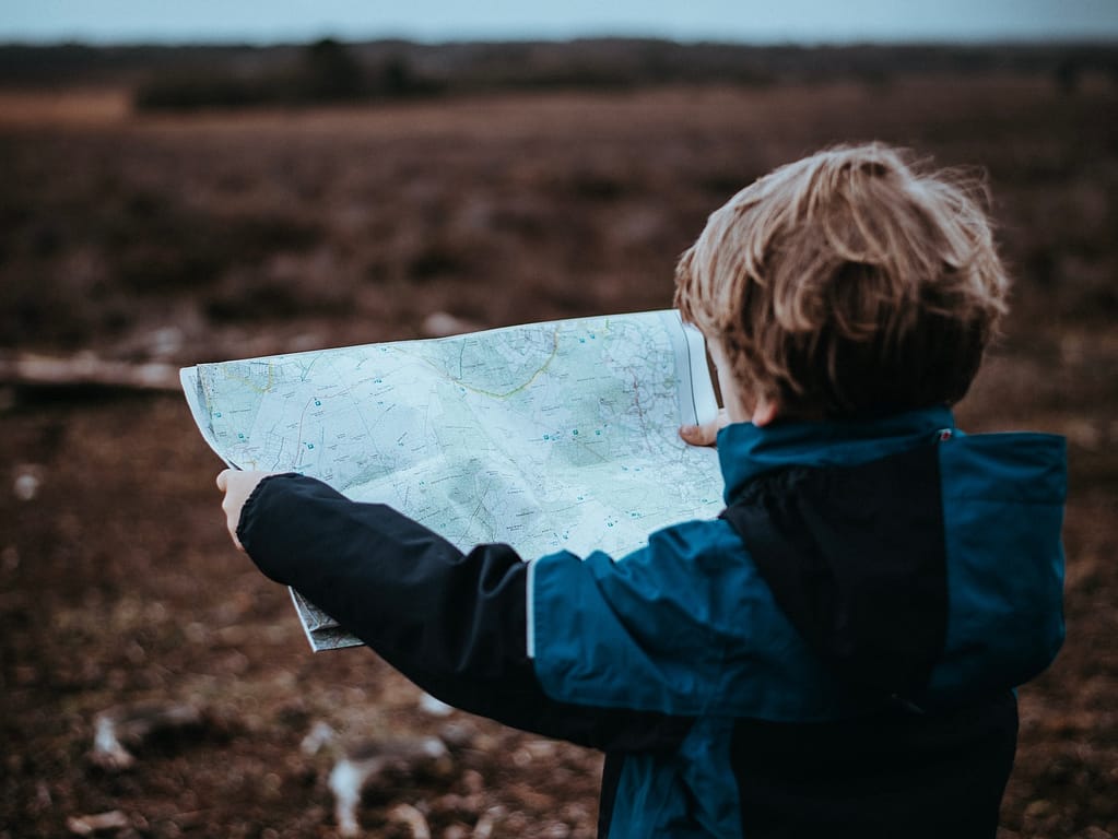 Kid looking at a map, learning how to plan a trip