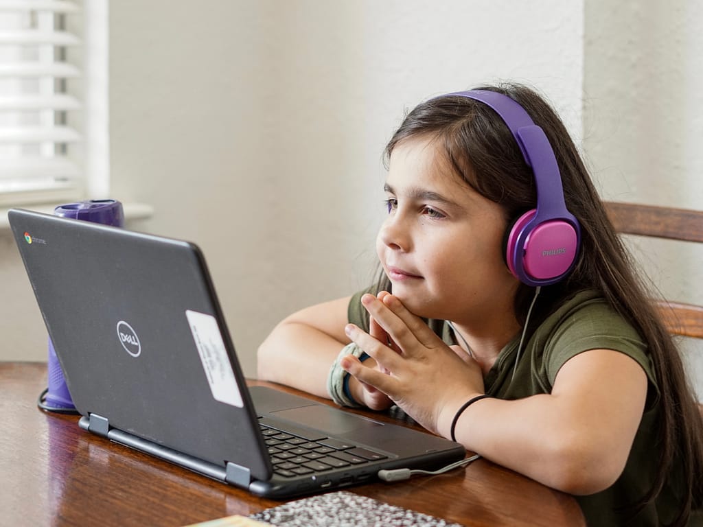 Kid researching on computer, learning how to plan a trip