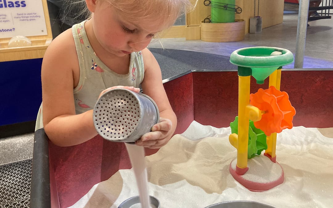 Girl playing in sand at Magic House, one of the best children’s museums