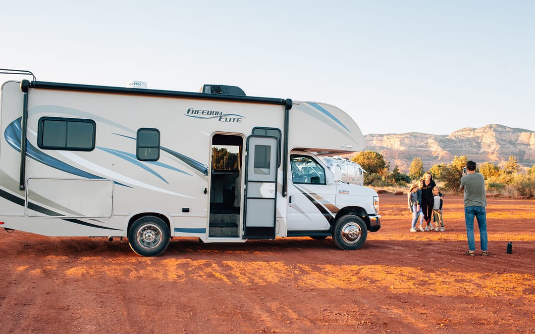 Family RV living taking a photo in front of motorhome