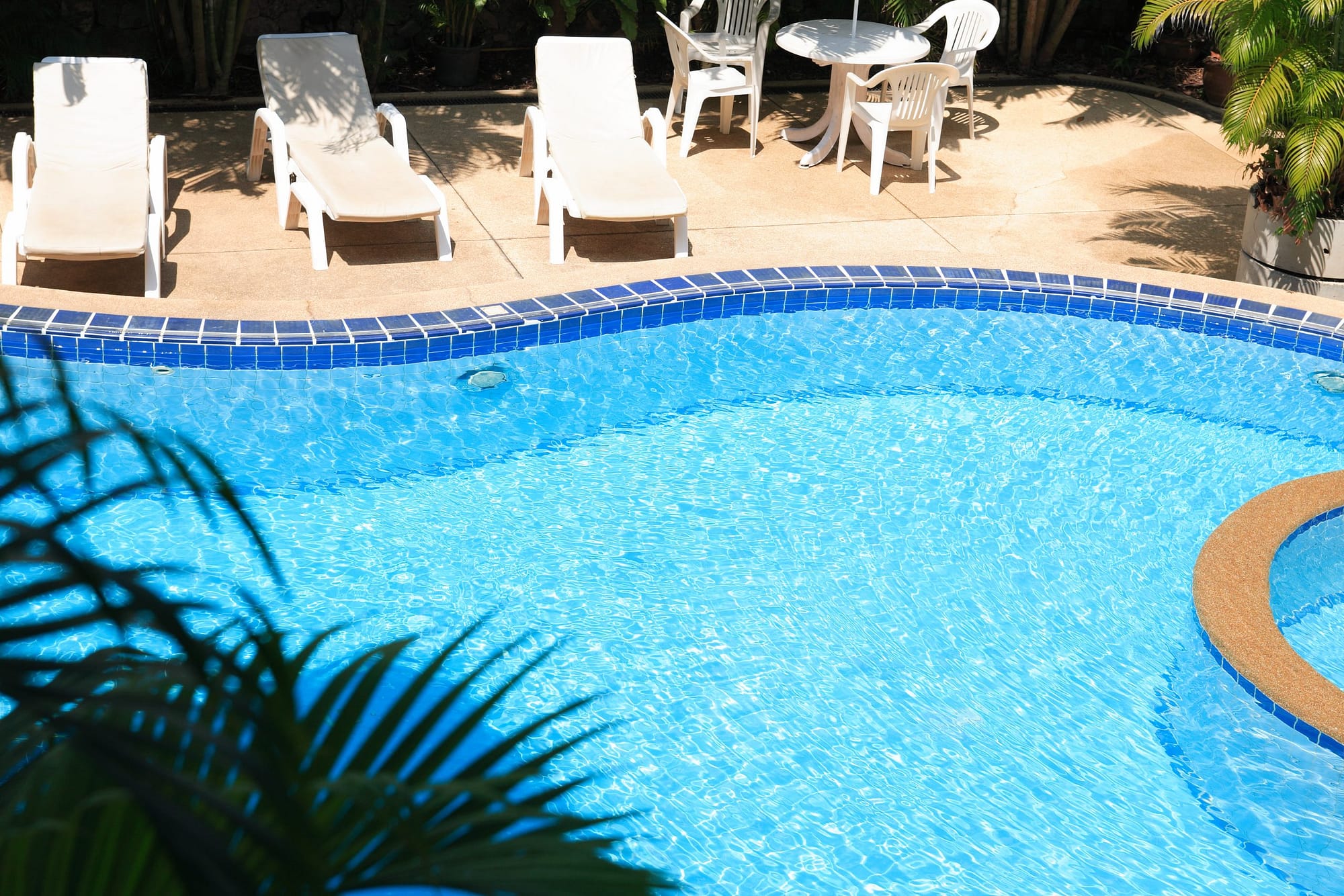 a beautiful and modern swimming pool with a unique tile and coping design