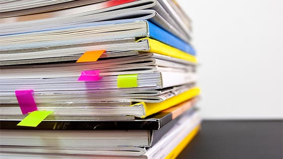 booklets and papers stacked on a wooden table; image used for blog post about what happens after a financial audit for a not-for-profit