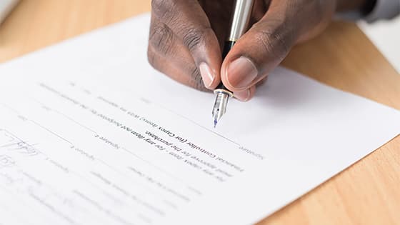 man signing agreement document; image used for blog post about not-for-profit organizations license agreements as a new revenue source