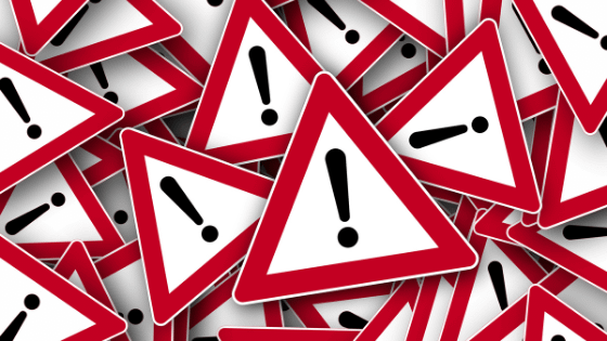 a pile of triangle signs with a red border and an exclamation point in the middle; image used for blog post about financial red flags for not-for-profit boards