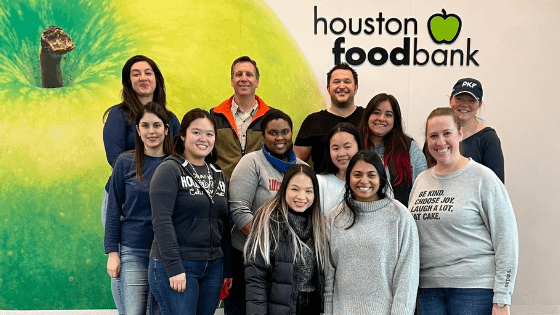 A group of PKF Texas Tax team members posing together at the Houston Food Bank for volunteering; image used for blog post about not-for-profits finding volunteers at local companies