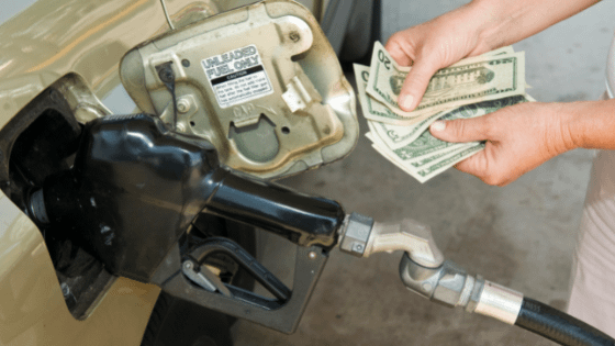 A photo of someone pumping fuel into their car with $20 bills; image used for blog post about IRS boosting mileage deduction rates