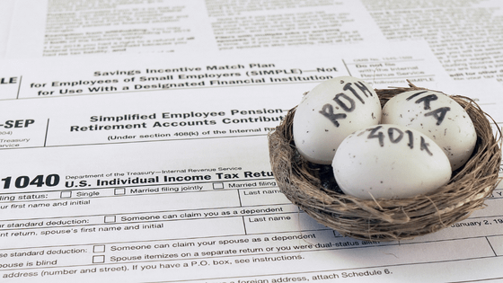 A photo of a nest of eggs with the words "Roth IRA 401(k)" sitting on top of a 1040 tax form; image used for blog post about solo 401(k) plan for self-employed