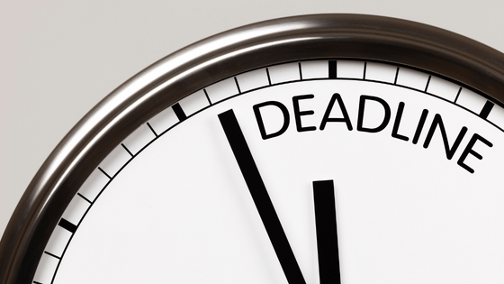 A close up view of a clock with the word "deadline;" for blog post about 2023 tax deadlines