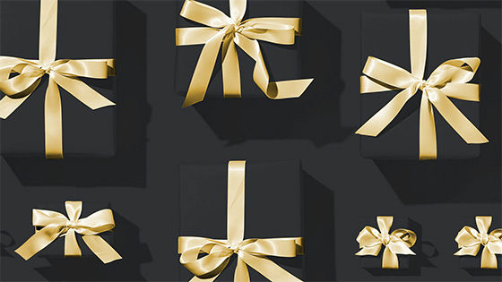 black box gifts with golden ribbon bows; image used for blog post about not-for-profit rules about gifts in kind