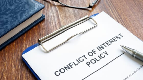 a paper with the words "Conflict-of-interest policy" in a clipboard and a pen on top; image used for blog post about not-for-profits creating a strong conflict-of-interest policy