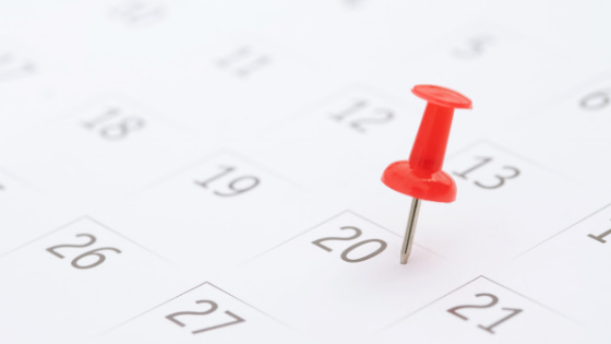 A pushpin stuck on a calendar on the 20th day of the month; image used for blog post about key 2022 Q2 tax deadlines for businesses