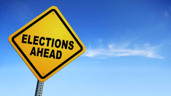 A caution sign with words, "Elections Ahead," with a clear sky in the background; image used for blog post about not-for-profits watching their activities during election season