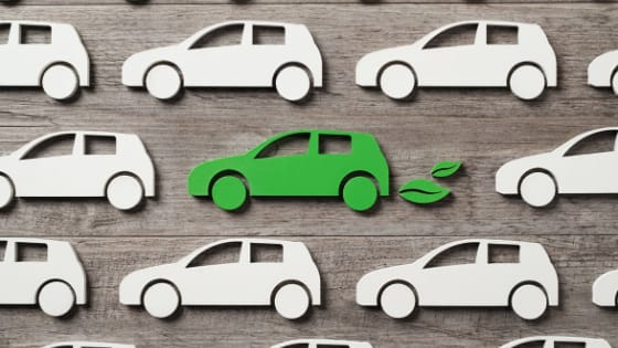 A photo of stencil cutouts of cars laid on top of a wooden surface; image used for blog post about EV tax credit