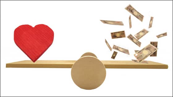 A photo of a balance holding a heart and falling money; image used for blog post about not-for-profits sharing values and limiting fraud losses