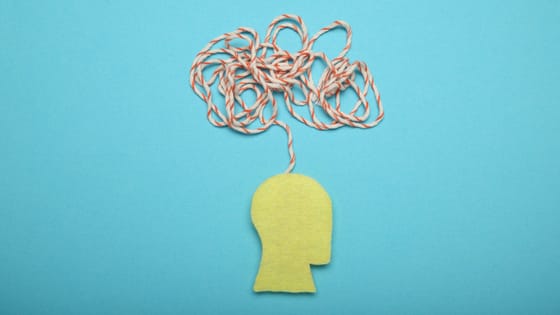 An image of construction paper forming a person's head with cloudy anxious tangled thoughts; image used for blog post about easing not-for-profit staff anxiety