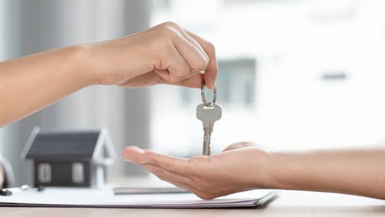 An image of two people exchanging a set of keys; for blog post about the tax consequences of renting to a relative
