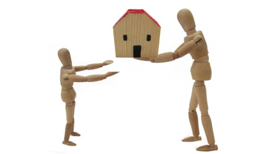 An image of two wooden figures holding a small wooden house; for blog post about inheriting property rules