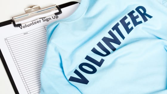 Photo of a t-shirt with the word "volunteer" sitting on top of a clipboard