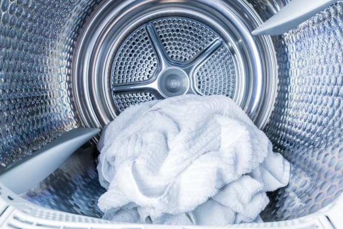 Interior of a clean dryer with a freshly laundered white towel