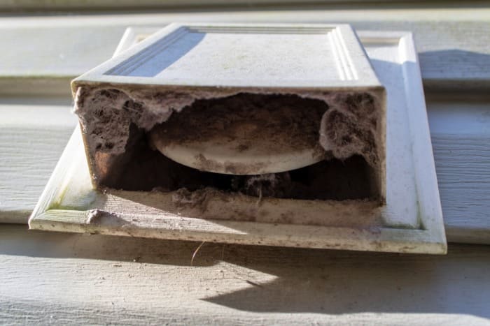 Clogged dryer vent filled with lint and debris, in need of cleaning and maintenance