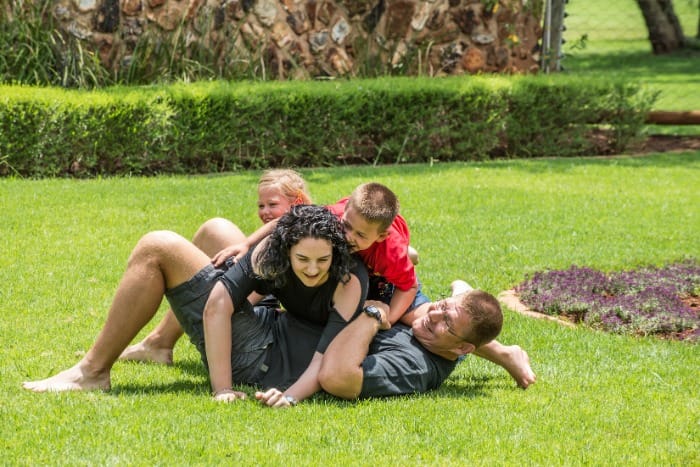 A happy family playing together on a well-maintained green lawn