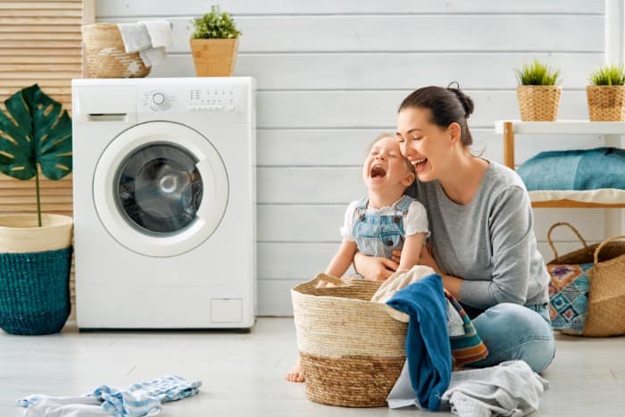 a joyful scene of a mother and her young child in a laundry room